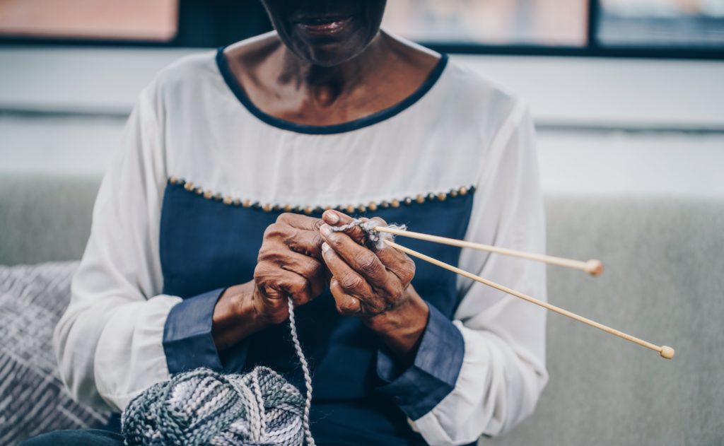 A socially isolated senior during COVID-19 pandemic knitting